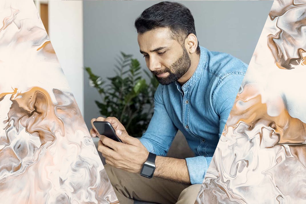 man holding phone while sitting on couch