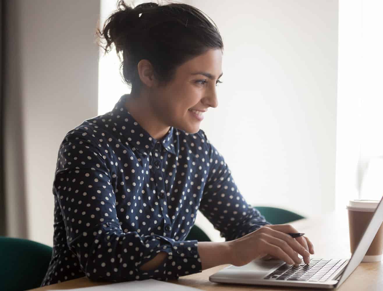 Woman working at desk on laptop
