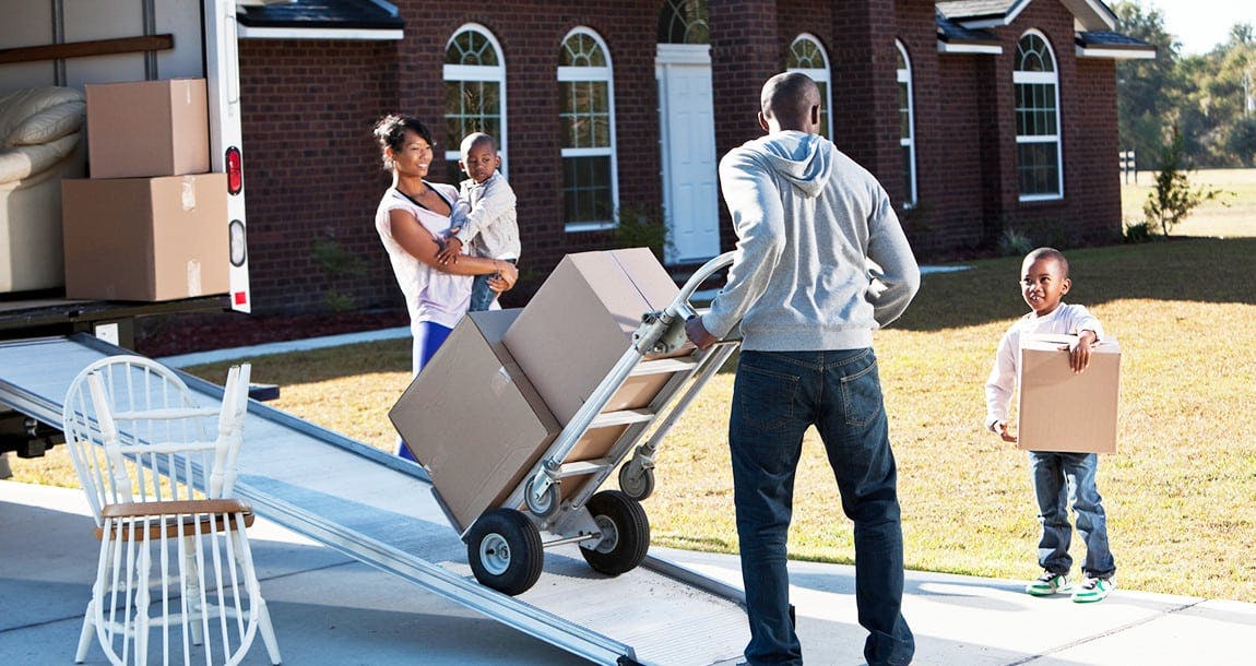 Family outside moving boxes into moving truck