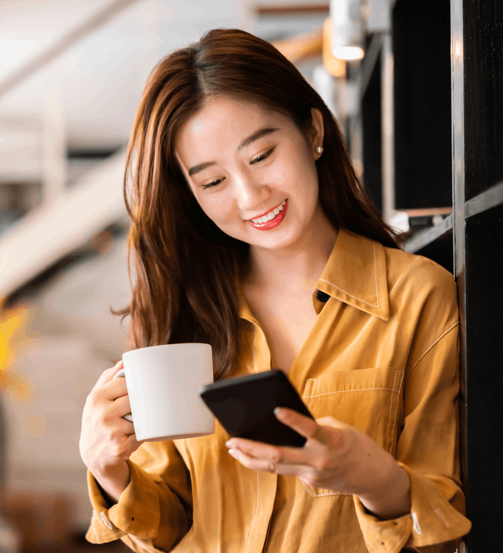 woman holding phone while drinking coffee