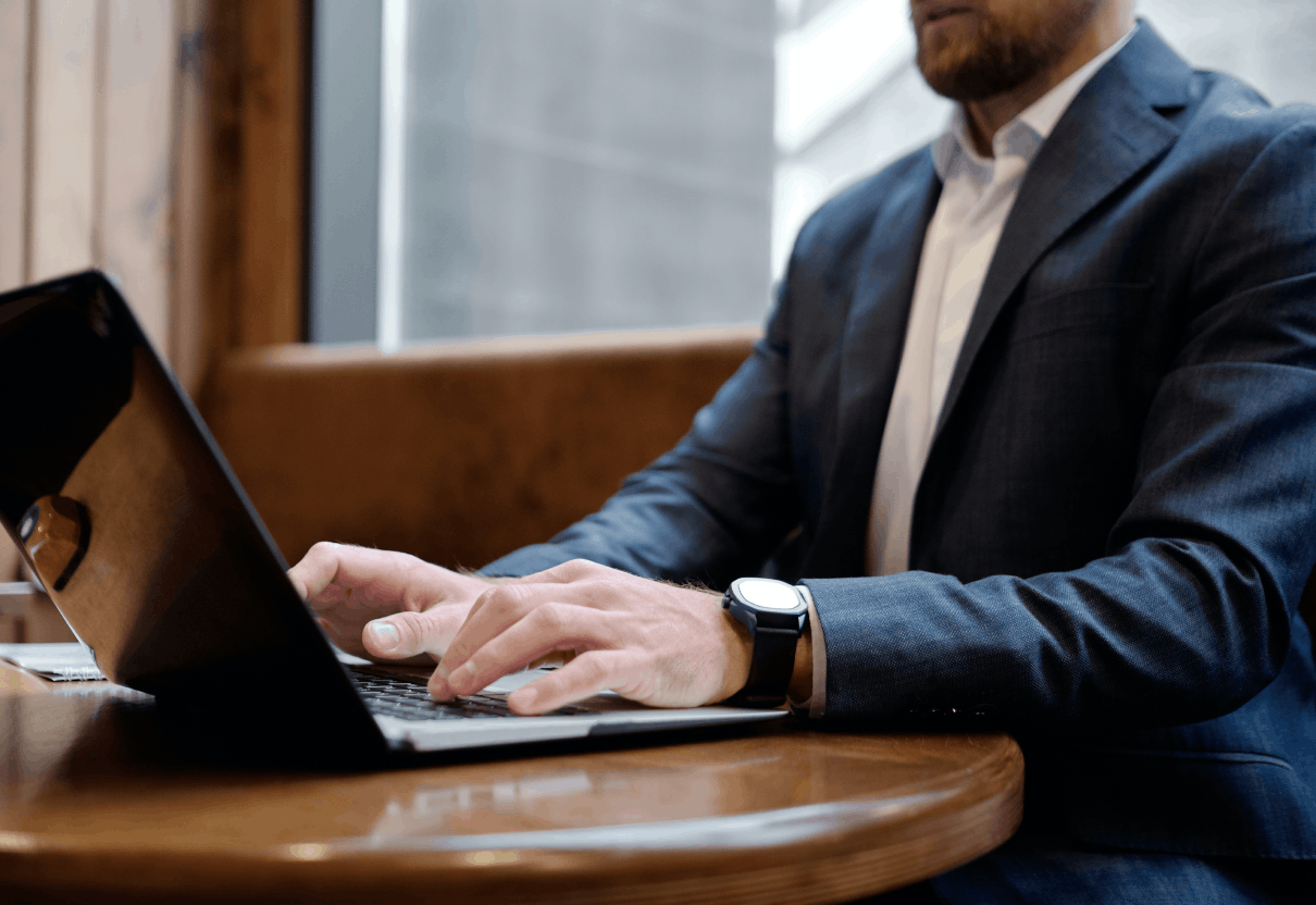 man in suit typing on laptop