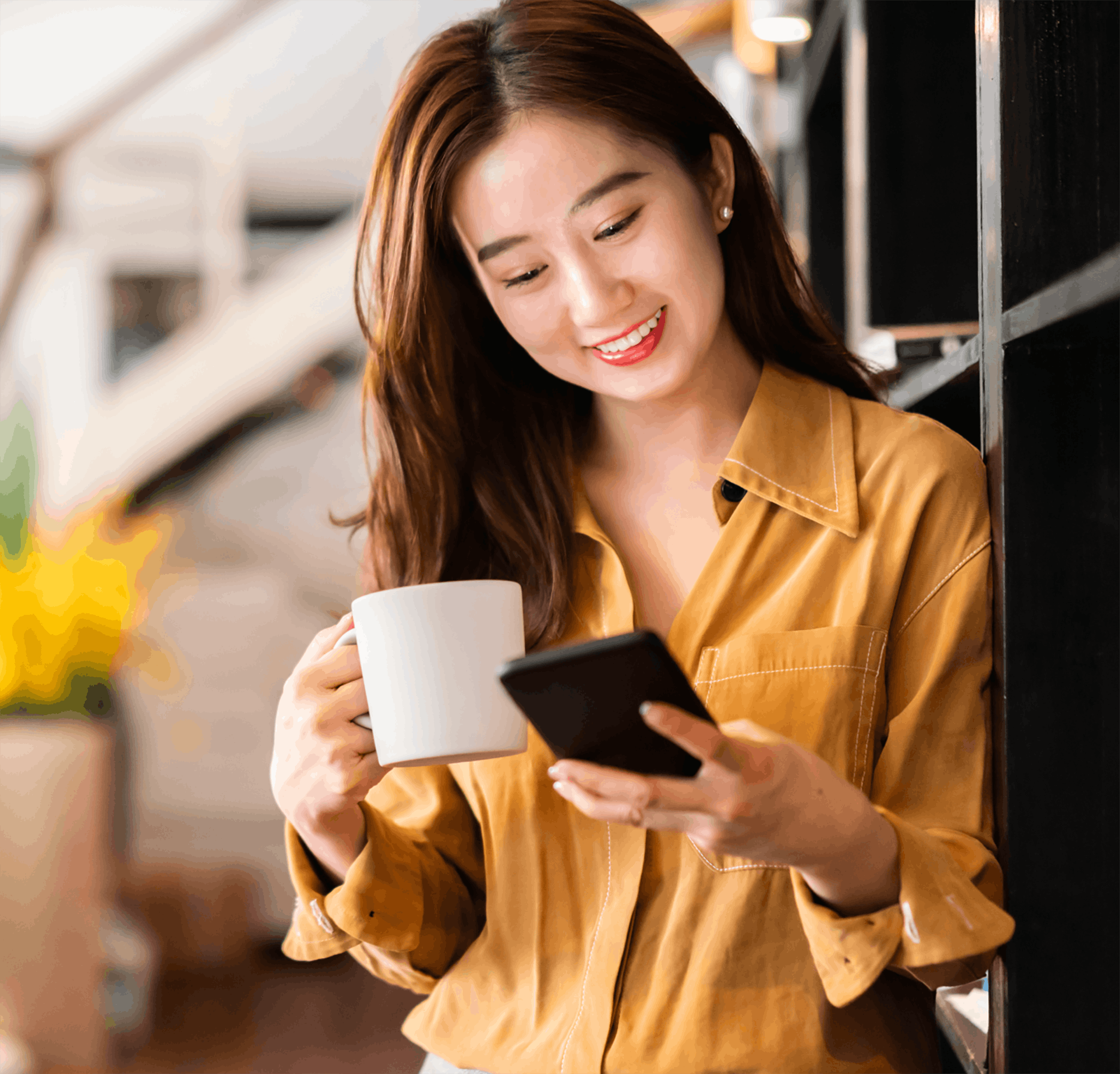 woman looking at phone while drinking coffee
