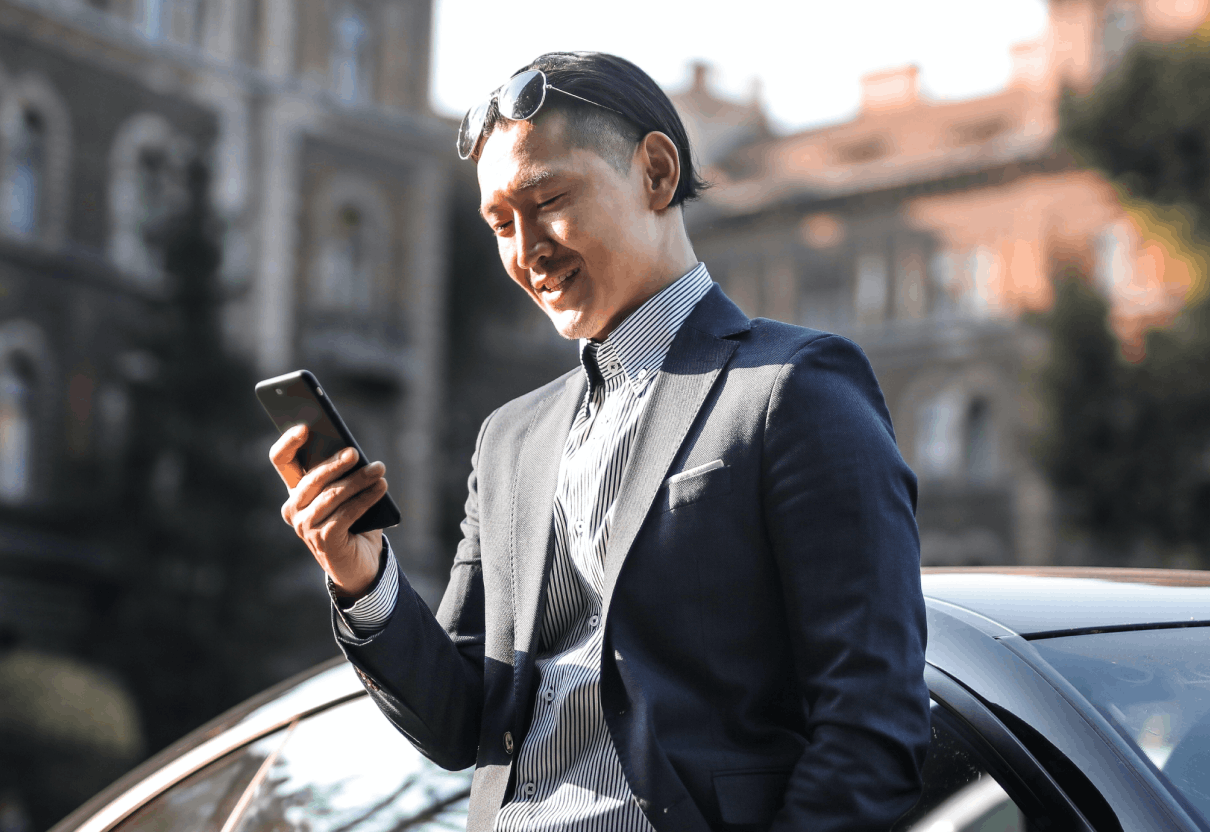 man in suit holding phone outside